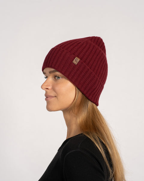 Unisex ribbed beanie in royal cherry red, knitted from Merino wool and cashmere, side profile view.