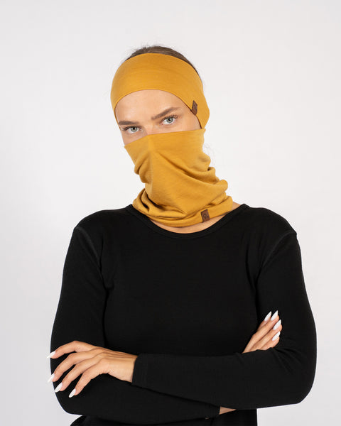 Woman wearing yellow Merino wool headband and matching gaiter set with black top.