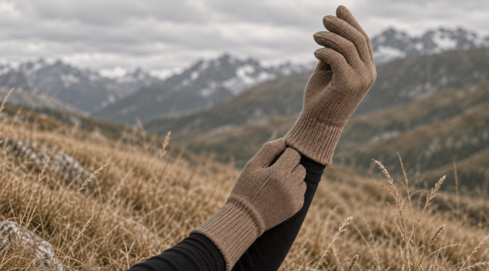 Woman outdoors holding her hands with creamy beige knitted merino wool gloves.