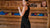 In the photo you can see woman standing, behind her there are exercising tools, such as weights. The woman is wearing black tank top with leggings made from organic 100% Merino Wool.