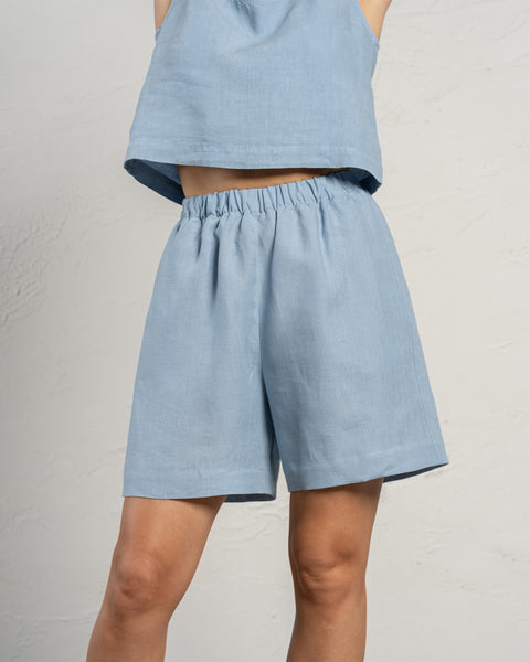Linen Bermuda shorts in the color cloudy blue. High-waisted longer shorts with pockets and elastic waistband.