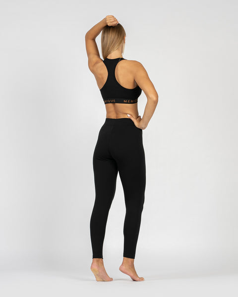 The menique women&#39;s merino wool sport bra in 160gsm and leggings in 250gsm fabric, black color, back view.