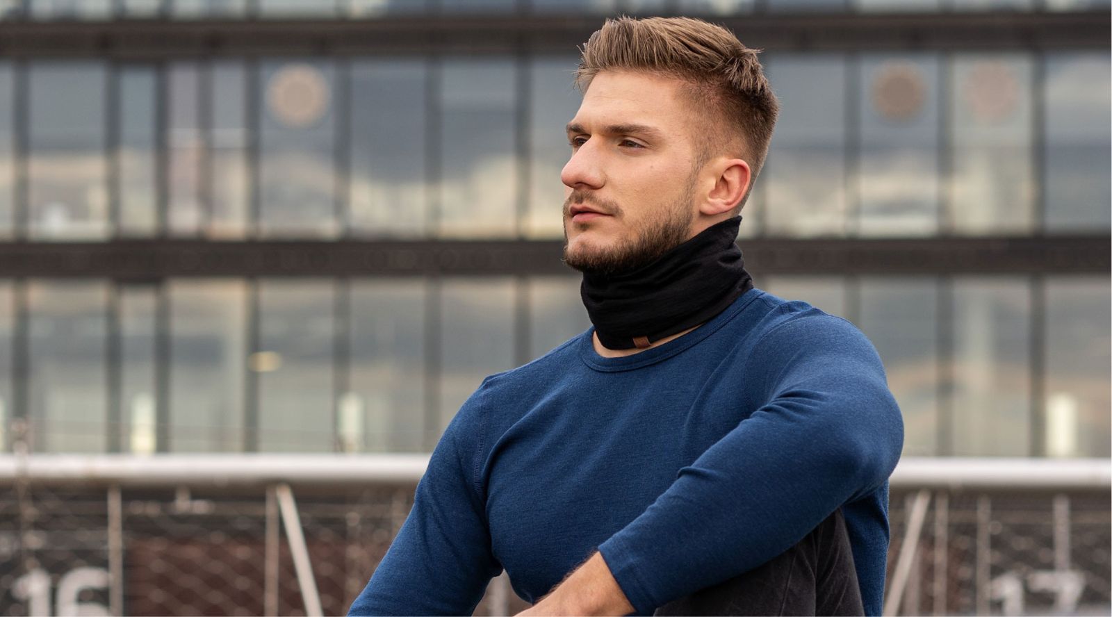 Man wearing a blue sweater with a blurred background