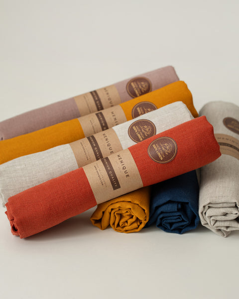 The menique linen dish towels in various colors, with their recyclable packaging.