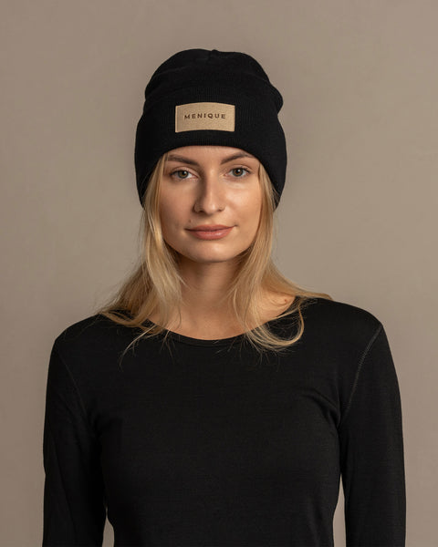 Woman wearing merino wool long sleeve top and knitted merino wool beanie with MENIQUE logo