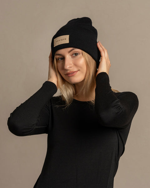 Woman wearing merino wool long sleeve top and knitted merino wool beanie with MENIQUE logo