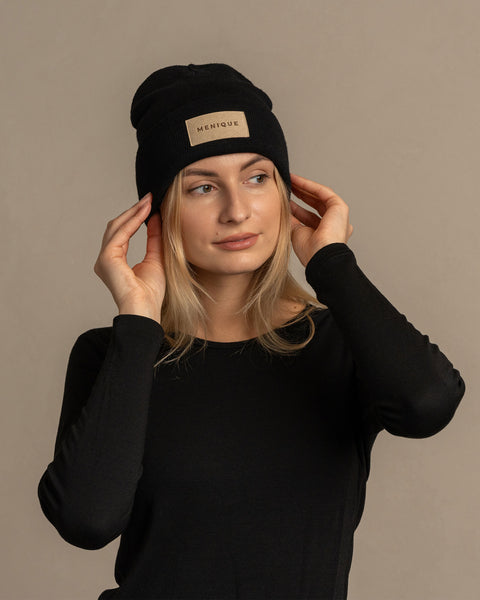 Woman wearing merino wool long sleeve top and knitted merino wool beanie with MENIQUE logo