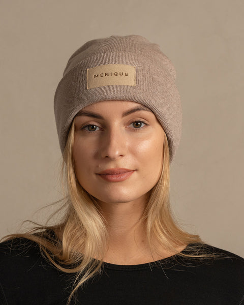 Woman wearing merino wool long sleeve top and knitted merino wool beanie with MENIQUE logo