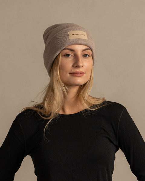Woman wearing merino wool long sleeve top and knitted merino wool beanie with MENIQUE logo