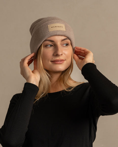 Woman wearing merino wool long sleeve top and knitted merino wool beanie with MENIQUE logo
