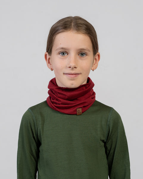 Smiling girl wearing a red Merino wool neck gaiter – soft, insulating, and moisture-wicking accessory for children.