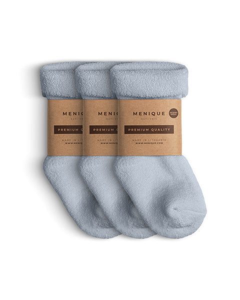 A 3-pack of kids’ light blue sherpa-lined merino wool socks with Menique branding.