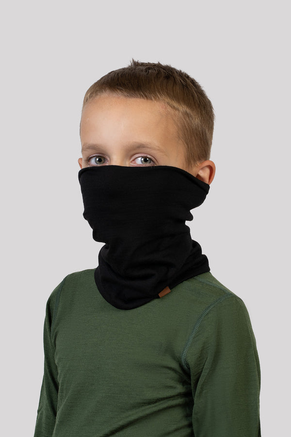 Boy wearing a black Merino wool neck gaiter and green base layer – soft, insulating neck warmer for children.