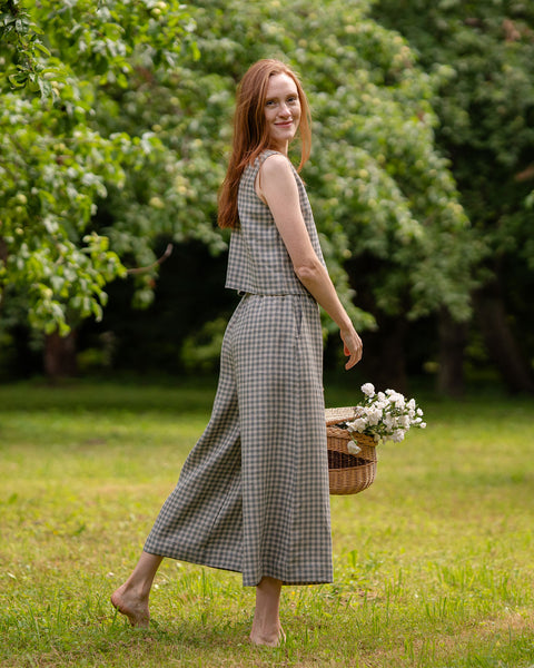 The model is wearing a matching set of the green gingham sleeveless blouse and culottes. She has turned sideways, showing the length of the crop top and slightly cropped pants. The wide leg design is visible.
