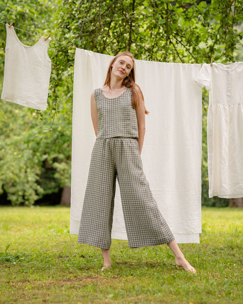 The model is facing the front, wearing the matching green gingham crop top and wide-leg pants two-piece. She is standing a bit wider than standard, with one of her legs slightly more to the side.