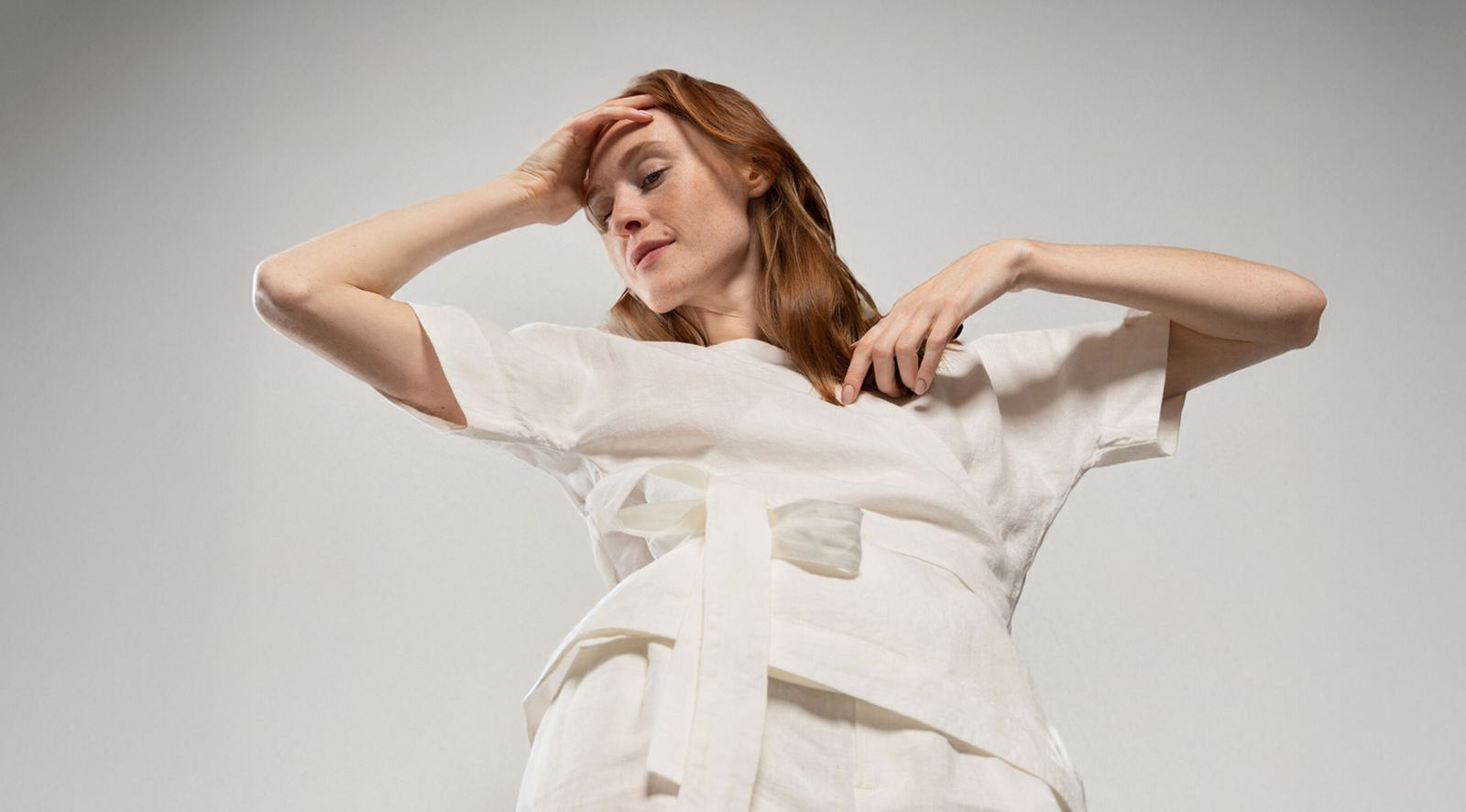 Woman wearing a white dress with a plain background