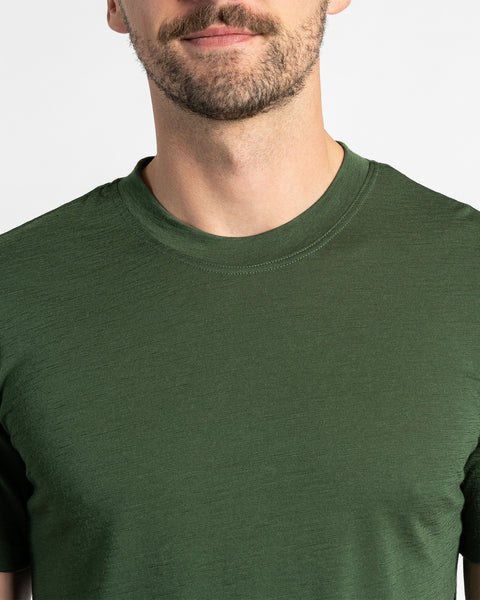 Close-up of a menique dark green t-shirt, showing the merino fabric texture and crew neck style.