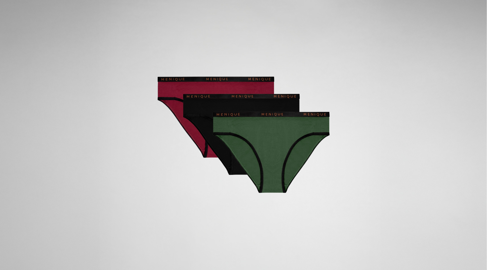 A layered stack of three bikini-cut panties in burgundy, black, and forest green. Each pair features black trim and a black elastic waistband with the brand name "MENIQUE" written in copper-colored text, displayed against a light grey background.