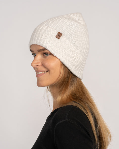 Unisex ribbed beanie in white, knitted from Merino wool and cashmere, side profile view.