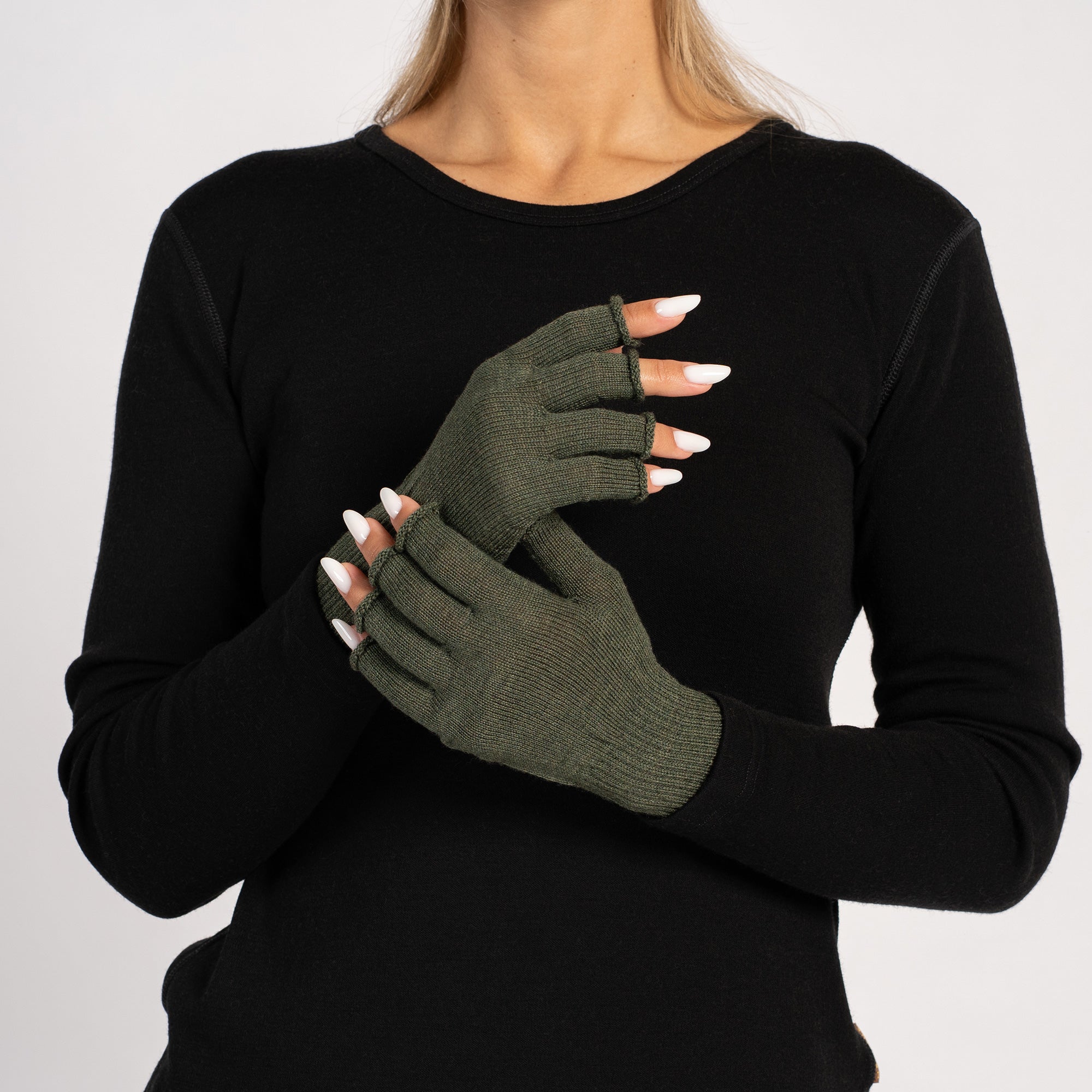 Close-up of creamy beige knitted Merino wool fingerless gloves for women with black sweater