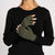 Close-up of creamy beige knitted Merino wool fingerless gloves for women with black sweater