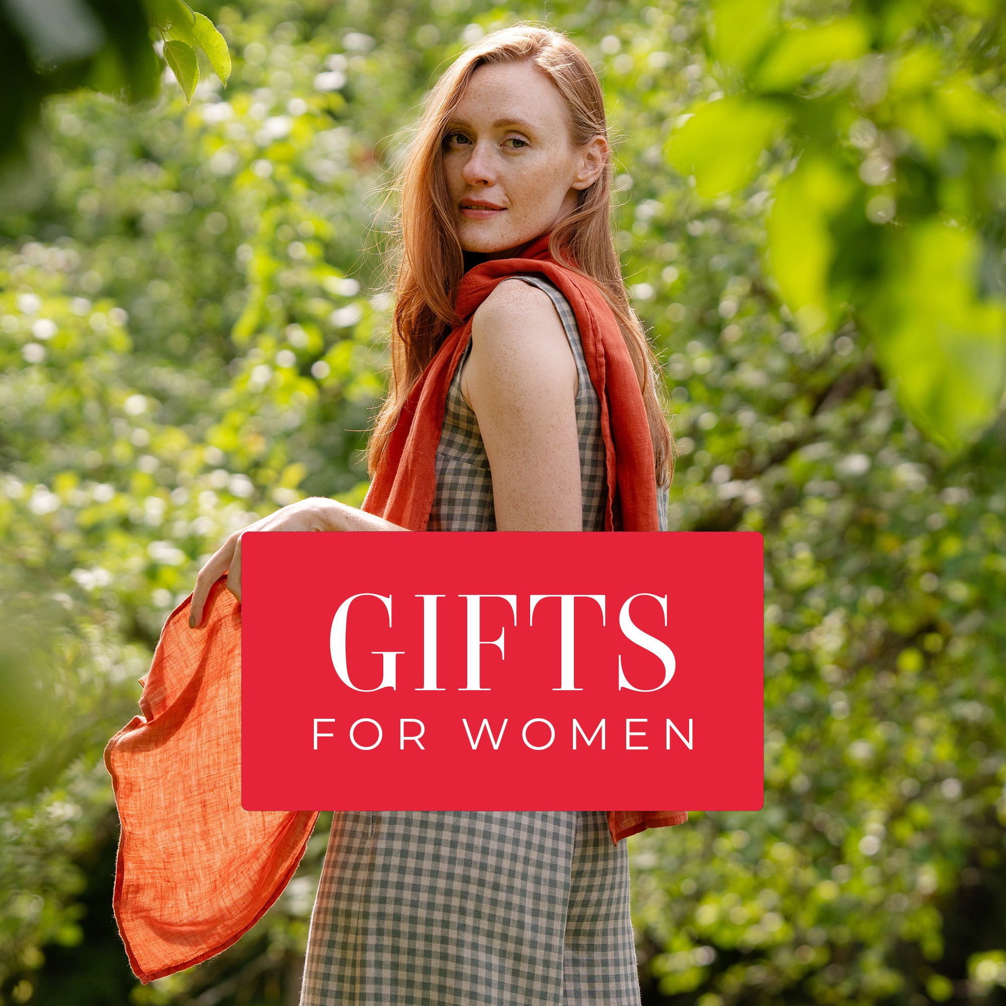A person wearing a checkered dress and orange scarf poses with the text "GIFTS FOR WOMEN" overlaid in a red square.
