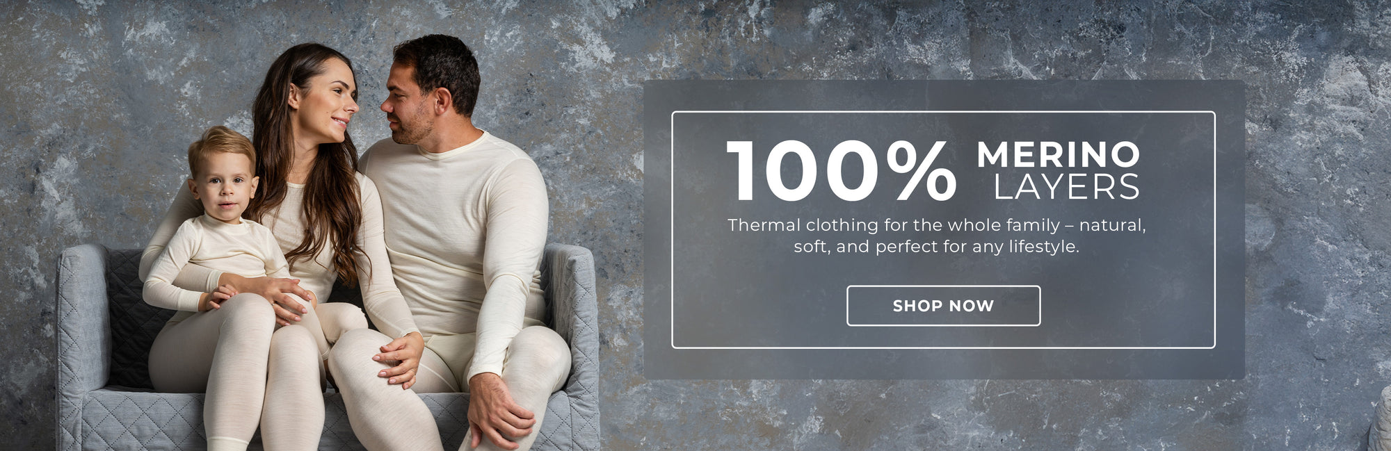 An advertisement featuring a family of three sitting on a gray tufted armchair. They are wearing matching off-white thermal clothing. The text "100% MERINO LAYERS" is displayed at the top, along with a description of the clothing and a "SHOP NOW" button. The background is a gray textured surface.


