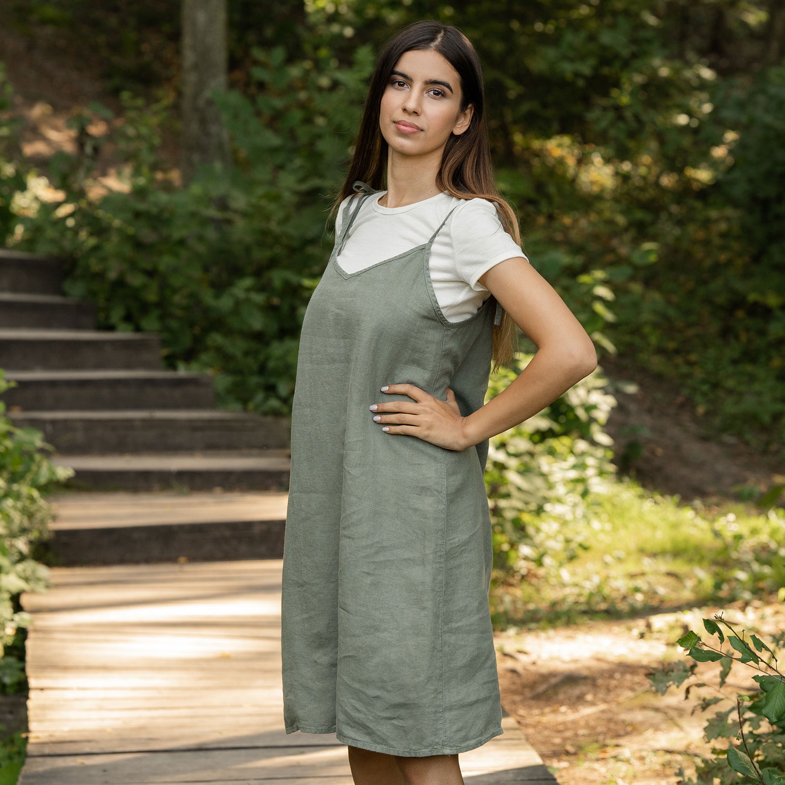 Woman standing in the forest and wearing slip dress from linen 