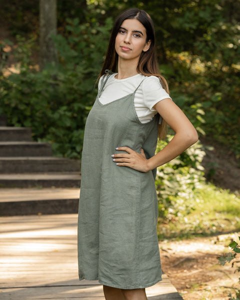 Woman standing in the forest and wearing slip dress from linen